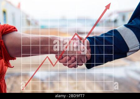 Concept of growth up in marine industry with rising graphics. marine contractor businessman handshaking with worker Stock Photo