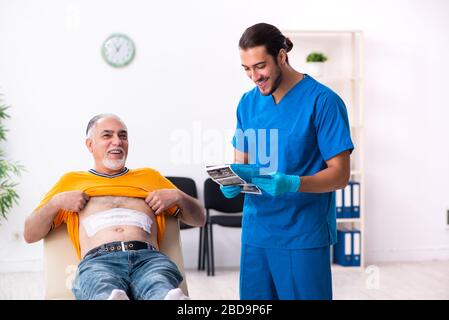 Old man visiting male doctor Stock Photo