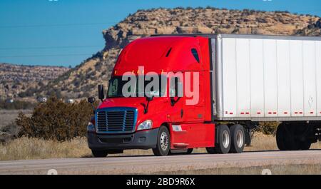 Eighteen wheel big rig tractor with trailer on highway. Trucking industry Stock Photo