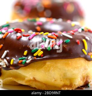 Chocolate glazed donuts with sprinkles on a white background Stock Photo