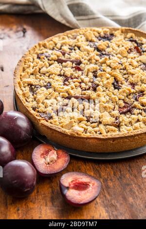 Sweet plum pie and plums on wooden table. Stock Photo