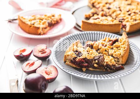Sweet plum pie. Cut pieces of pie on plate. Stock Photo