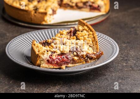 Sweet plum pie. Cut pieces of pie on plate. Stock Photo