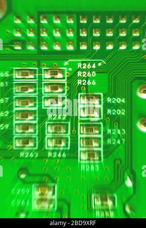 zoom effect closeup yellow-green micro circuit resistors of a computer motherboard Stock Photo