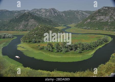 Rijeka Crnojeviæa, part of the Skadar Lake in Montenegro. Tourist cruises by boat on the beautiful meanders of the river flowing between the hills. Stock Photo