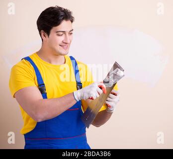 The young contractor employee applying plaster on wall Stock Photo