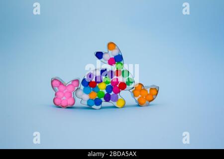 Rabbit bunny and bird shaped forms for gingerbread decorated with colorful balls inside on blue background with copy space. Easter concept Stock Photo