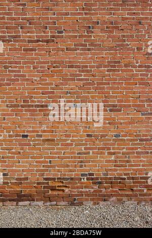 Antique red and brown exterior clay brick wall texture background, with rugged deterioration, photographed in sunlight, Stock Photo