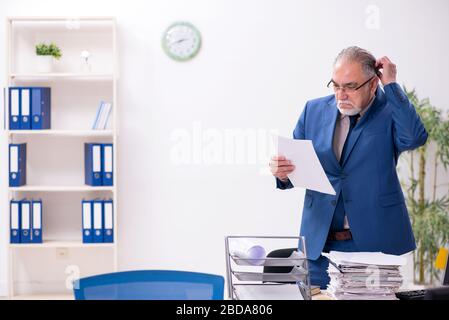 Old employee and too much work in the office Stock Photo