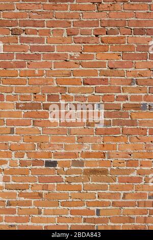 Antique red and brown exterior clay brick wall texture background, with rugged deterioration, photographed in sunlight, Stock Photo