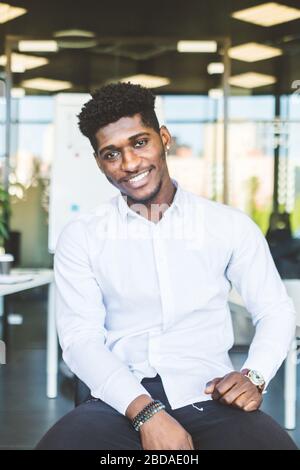 Group of multi ethnic executives discussing during a meeting. Business man and woman sitting around table at office and smiling. A team of young Stock Photo