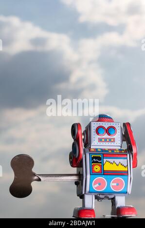 Vintage toy robot with sky behind. Artificial intelligence concept. Stock Photo