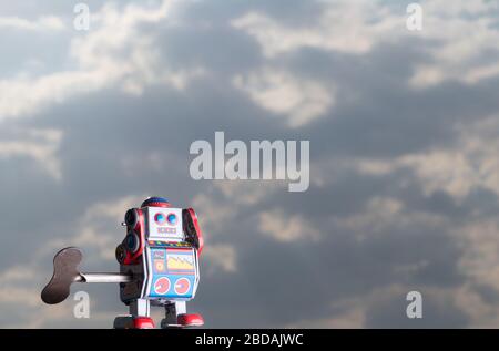Vintage toy robot with sky behind. Artificial intelligence concept. Stock Photo