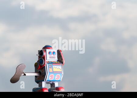 Vintage toy robot with sky behind. Artificial intelligence concept. Stock Photo