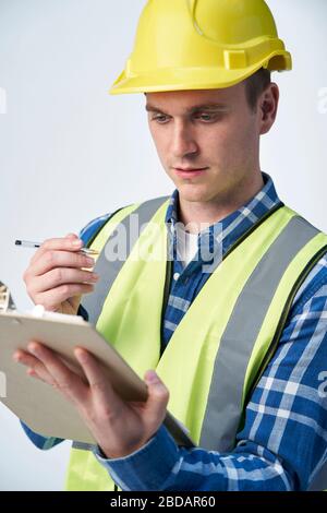 Builder Architect Making Notes On Clipboard Against White Background Stock Photo