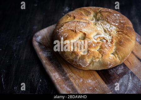 Home made crusty bread on a wooden paddle. Stock Photo