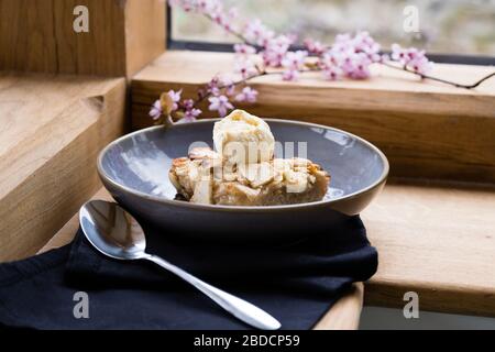 Apple cake and ice cream in a bowl with a spoon Stock Photo