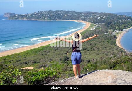 A woman looking at the scenic landscape of the Palm beach in Sydney, Australia Stock Photo