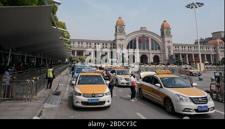 Wuhan, China. 8th Apr, 2020. Passengers take the taxi in front of the Hankou Railway Station in Wuhan, central China, April 8, 2020. Wuhan, the central Chinese city hard-hit by the novel coronavirus outbreak, restored its taxi service from Wednesday. The public needs to go through real-name registration for taking taxis in Wuhan. Credit: Wang Yuguo/Xinhua/Alamy Live News Stock Photo
