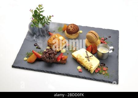 Various desserts served on the black plate Stock Photo