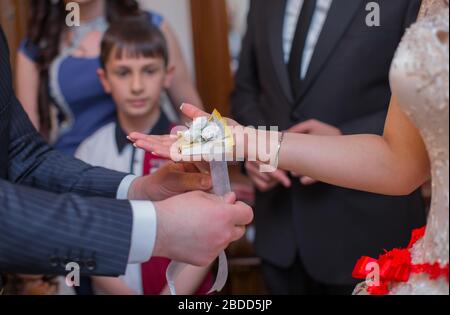 The bride ties a ribbon over her hand . He ties a ribbon over his hand. Stock Photo