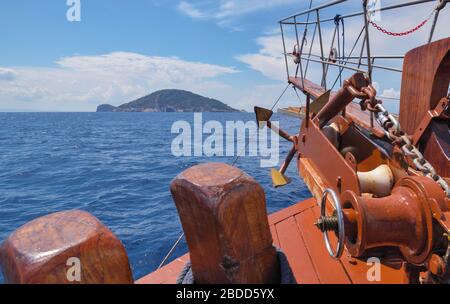 A anchor, ropes and bow of a wooden sailing yacht against the background of the sea and the blue sky Stock Photo