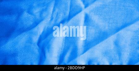 Texture of classic blue Wrinkled Fabric. Trendy color of clothes. Close-up. Stock Photo