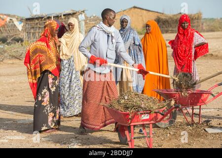 11.11.2019, Burferedo, Somali Region, Ethiopia - Villagers clean up the village square with shovels from animal dung. Clean up campaign OWDA in the vi Stock Photo