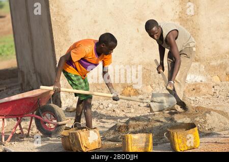 11.11.2019, Burferedo, Somali Region, Ethiopia - Construction workers mixing cement mortar with shovels. Construction of a pumping station to supply t Stock Photo