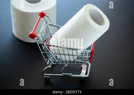 Toilet paper in toy shopping cart, stockpiling concept due to coronavirus outbreak Stock Photo