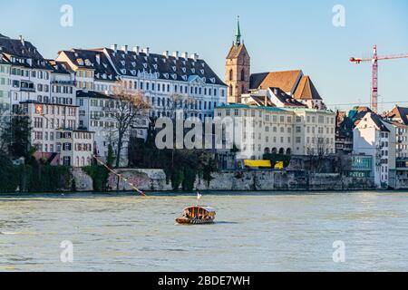 One of four cable ferries that cross the river Rhine in central Basel, with the minster / cathedral behind. Basel, Switzerland. February 2020. Stock Photo