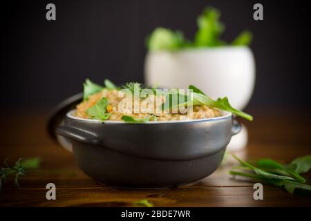 boiled bulgur groats with vegetables and herbs in a ceramic bowl Stock Photo