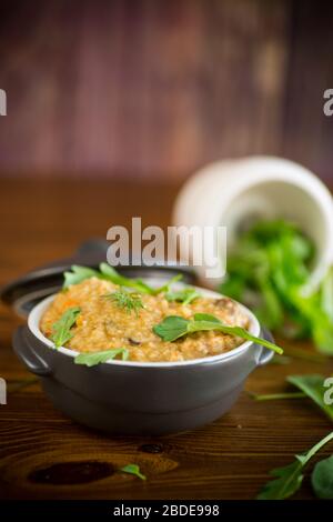 boiled bulgur groats with vegetables and herbs in a ceramic bowl Stock Photo