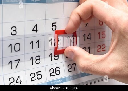 The hand on the calendar moves the pointer from the twelfth to the thirteenth Stock Photo