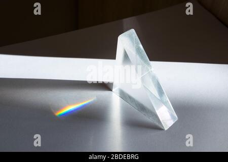 Sunlight passes through a prism, causing the light to refract and spread, creating a spectrum of colors Stock Photo
