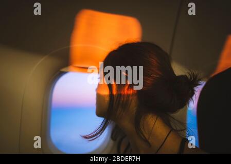 Portrait of young woman in plane illuminated with sunset light Stock Photo