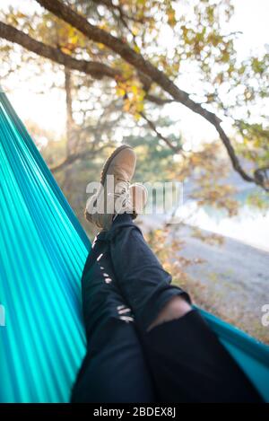 Italy, Man lying in hammock near lake Stock Photo
