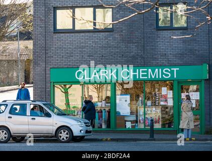Leith, Edinburgh, Scotland, UK, 8th Apr 2020. Covid-19 lockdown: people continue in lockdown and maintain social distancing. People queue outside a chemist shop