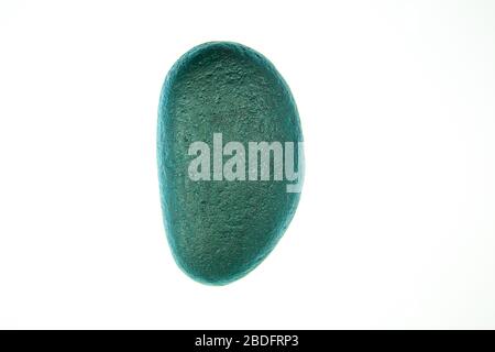 Single Turquoise painted stone with isolated white background Stock Photo
