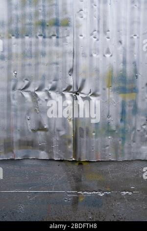 Row of indentation marks on silver spray painted metal wall, close up Stock Photo