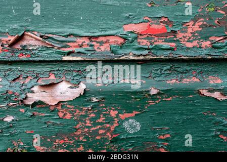 Peeling paint on boards exposing previous colour scheme/undercoat Stock Photo