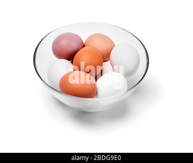 eggs of different shades from white to brown in a glass bowl, isolated on a white background Stock Photo