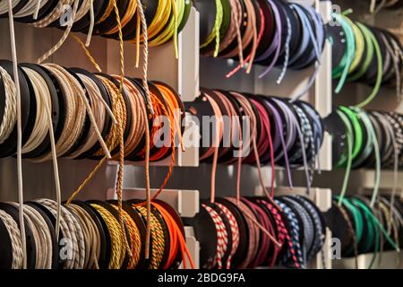 Stand with coils of multicolored textile braided cables Stock Photo