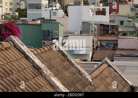 French Colonial tiled roof line with view of various urban residential architecture styles, some modern and some old in Ho Chi Minh City, Vietnam. Stock Photo