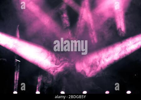 Pink ray of light with smoke and fog spotlights on the stage. Scene light equipment background Stock Photo