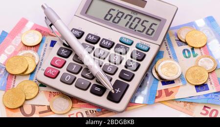 heap of banknotes of Euo currency with coins and calculator Stock Photo