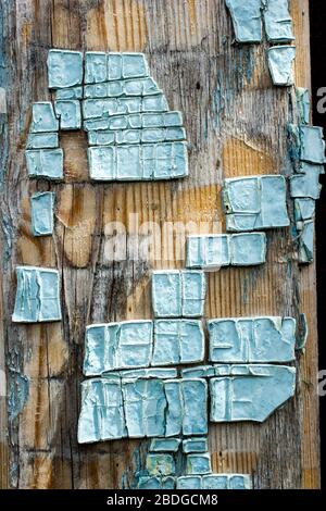 Part of old wooden boards painted in light blue cracked paint with several layers of shelled paint pieces Stock Photo