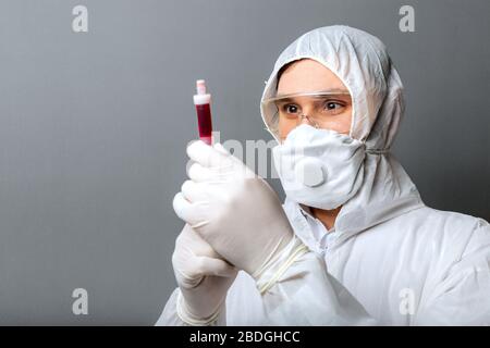 Coronavirus, covid-19 blood test in doctors hands. Doctor in protective medical suit, biological hazard, medical mask FFP3, goggles safety glasses on Stock Photo