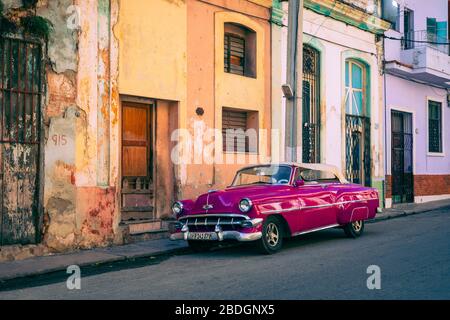 HAVANA, CUBA - DECEMBER 10, 2019: Havana Cuba Classic Cars. Typcal Havana urban scene with colorful buildings and old cars. Stock Photo