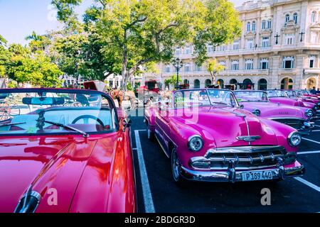 HAVANA, CUBA - DECEMBER 10, 2019: Havana Cuba Classic Cars. Typcal Havana urban scene with colorful buildings and old cars. Stock Photo